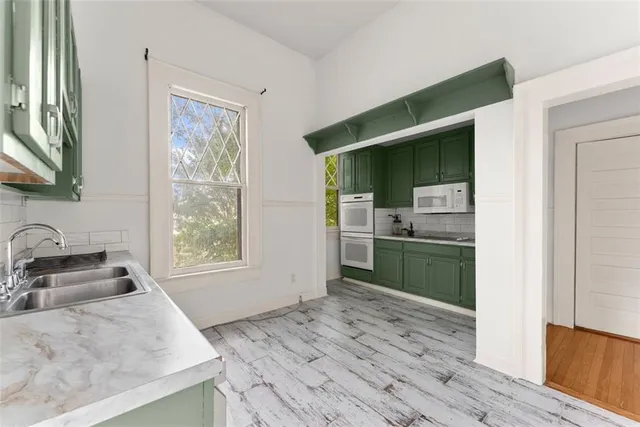 a kitchen with granite countertop a sink cabinets and wooden floor