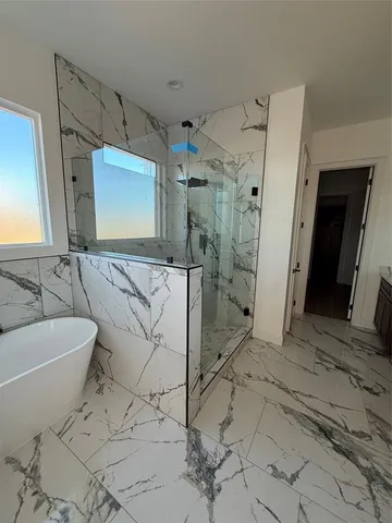 a spacious bathroom with a bathtub and a shower