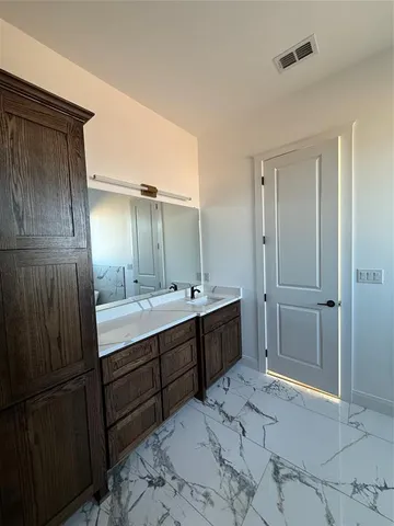 a bathroom with a double vanity sink mirror and shower