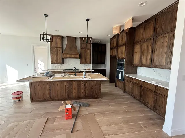 a kitchen with kitchen island granite countertop a stove a sink and a refrigerator