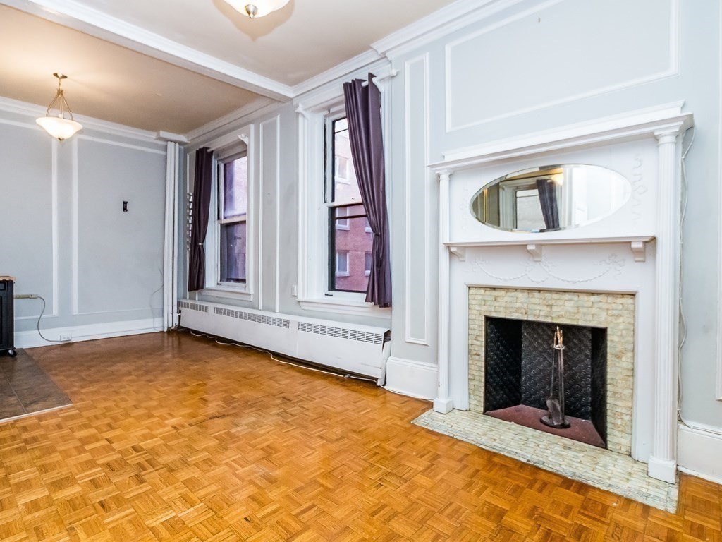 21 Beacon Street, Unit 4Q Boston, MA 02108 - Photo 2 of 9 a view of an empty room with a fireplace and a window
