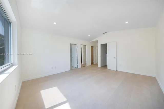 an empty room with windows and closet