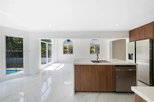 a kitchen with a sink refrigerator and window