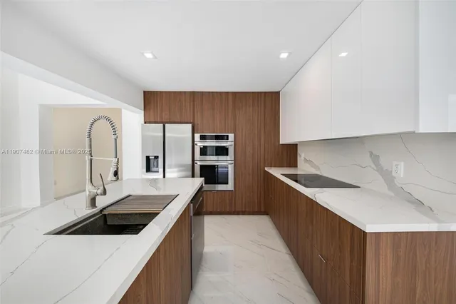 a view of a kitchen with a sink and a refrigerator