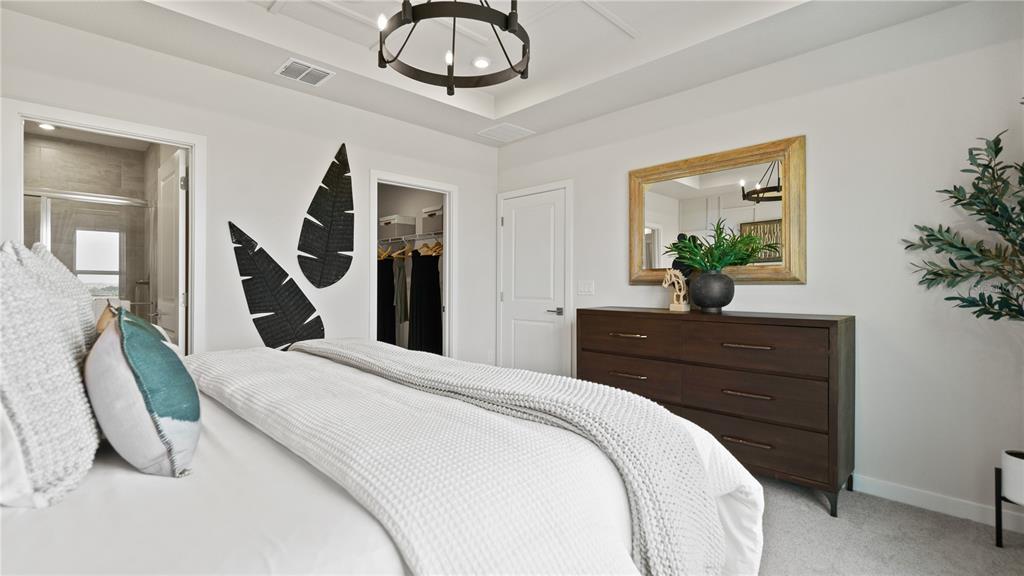 1353 June Lake Loop Haines City, FL 33844 - Photo 36 of 44 a bedroom with a large bed and a chandelier