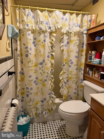 a bathroom with a toilet and a shower curtain
