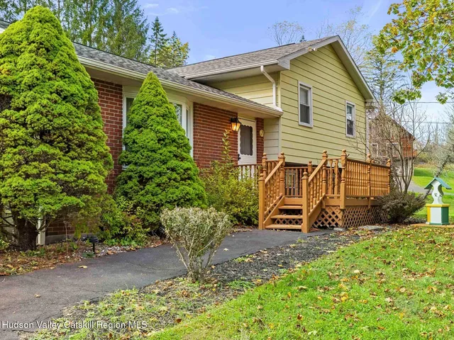 a view of a house with a small yard and sitting area