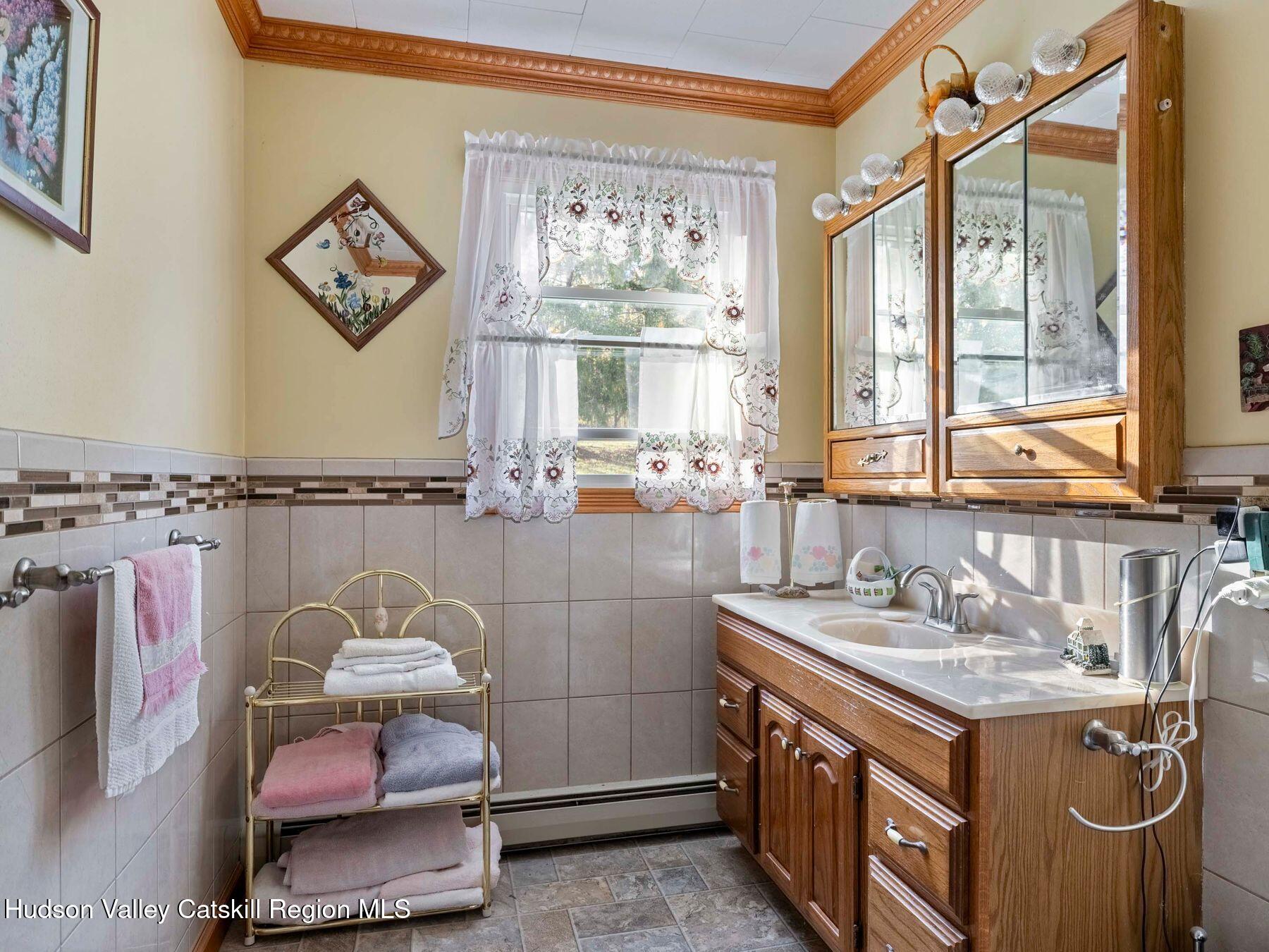 1339 Cornwallville Road Cornwallville, NY 12418 - Photo 32 of 47 a bathroom with a granite countertop sink a large mirror and a window