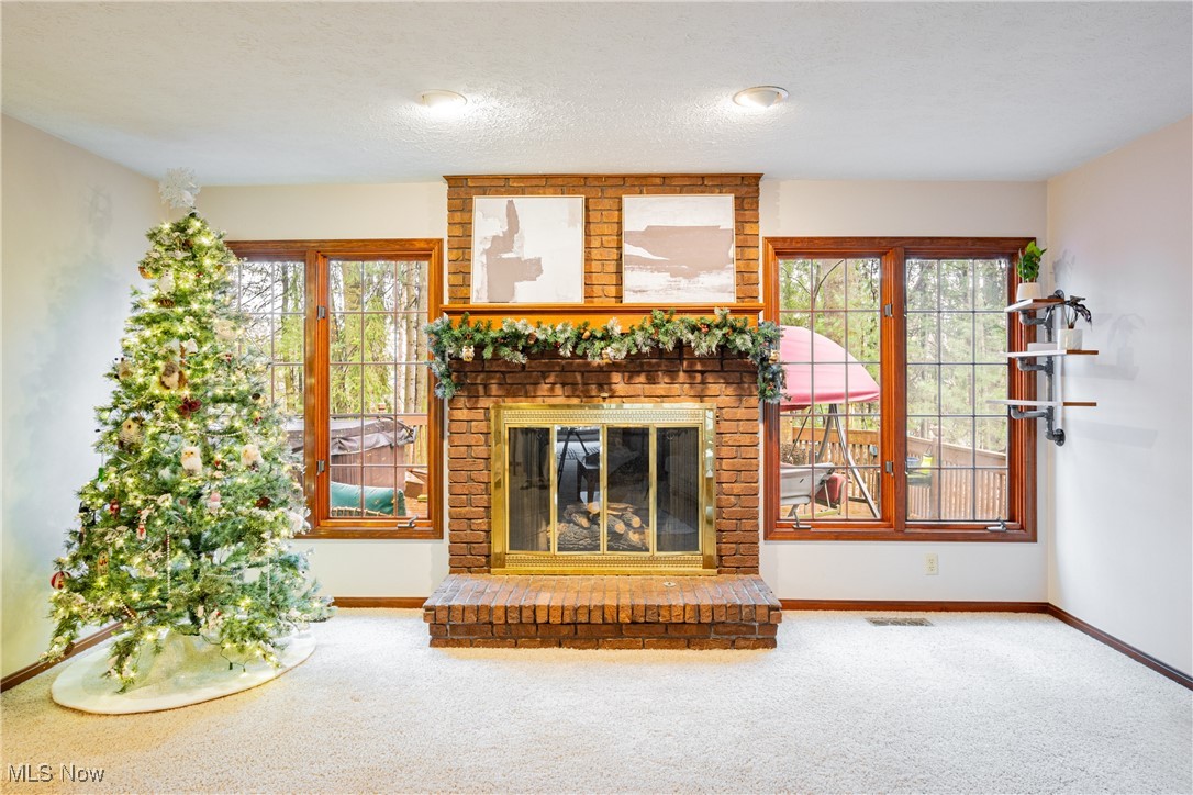 6743 Cedar Ridge Trail Clinton, OH 44216 - Photo 15 of 42 Unfurnished living room with carpet, plenty of natural light, and a fireplace