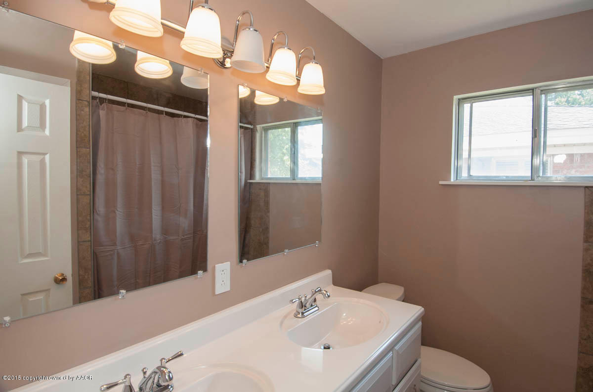 6016 Gainsborough Road Amarillo, TX 79106 - Photo 22 of 36 a bathroom with a sink a toilet and mirror