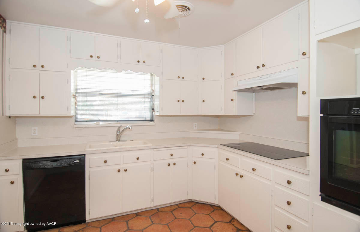 6016 Gainsborough Road Amarillo, TX 79106 - Photo 9 of 36 a kitchen with cabinets appliances a sink and a window