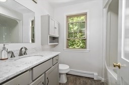 6 Mellen Street Hopedale, MA 01747 - Photo 23 of 42 a bathroom with a granite countertop sink a large mirror a toilet and a window