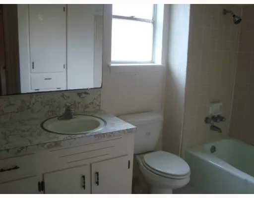 a bathroom with a sink toilet a vanity and bathtub