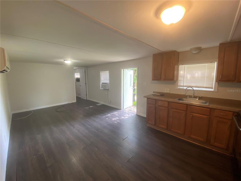 38313 Tucker Road, Unit 3 Zephyrhills, FL 33542 - Photo 6 of 20 a view of a kitchen with a sink and dishwasher with wooden floor