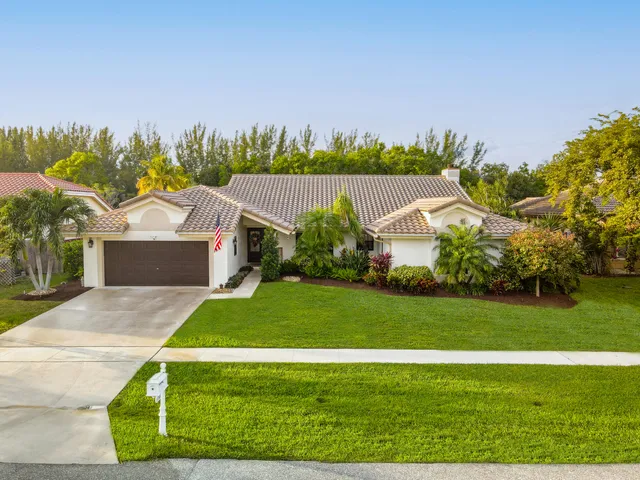 a front view of a house with a yard and trees