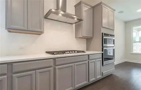 a kitchen with stainless steel appliances granite countertop white cabinets and a stove