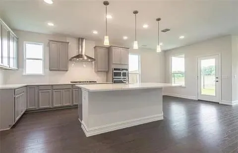a large kitchen with kitchen island white cabinets and stainless steel appliances