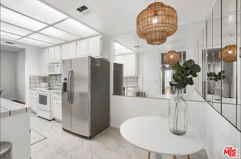 a kitchen with refrigerator a microwave a sink and cabinets