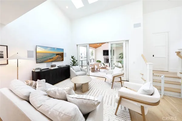 a living room with furniture a chandelier and a wooden floor