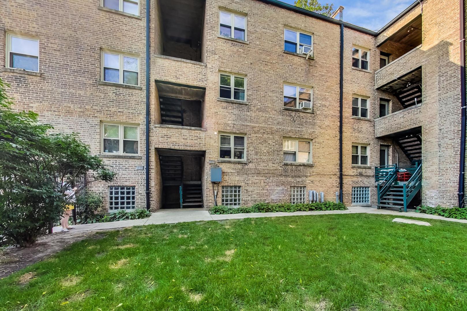 205 Custer Avenue, Unit 3 Evanston, IL 60202 - Photo 11 of 12 a view of a brick house with a large windows and a yard