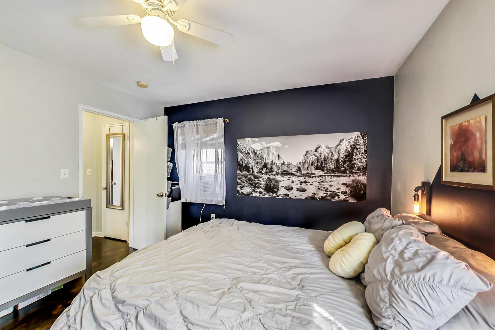 205 Custer Avenue, Unit 3 Evanston, IL 60202 - Photo 8 of 12 a bedroom with a bed and a chandelier