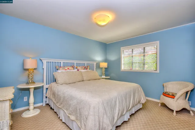 a bedroom with a bed and painting on the wall