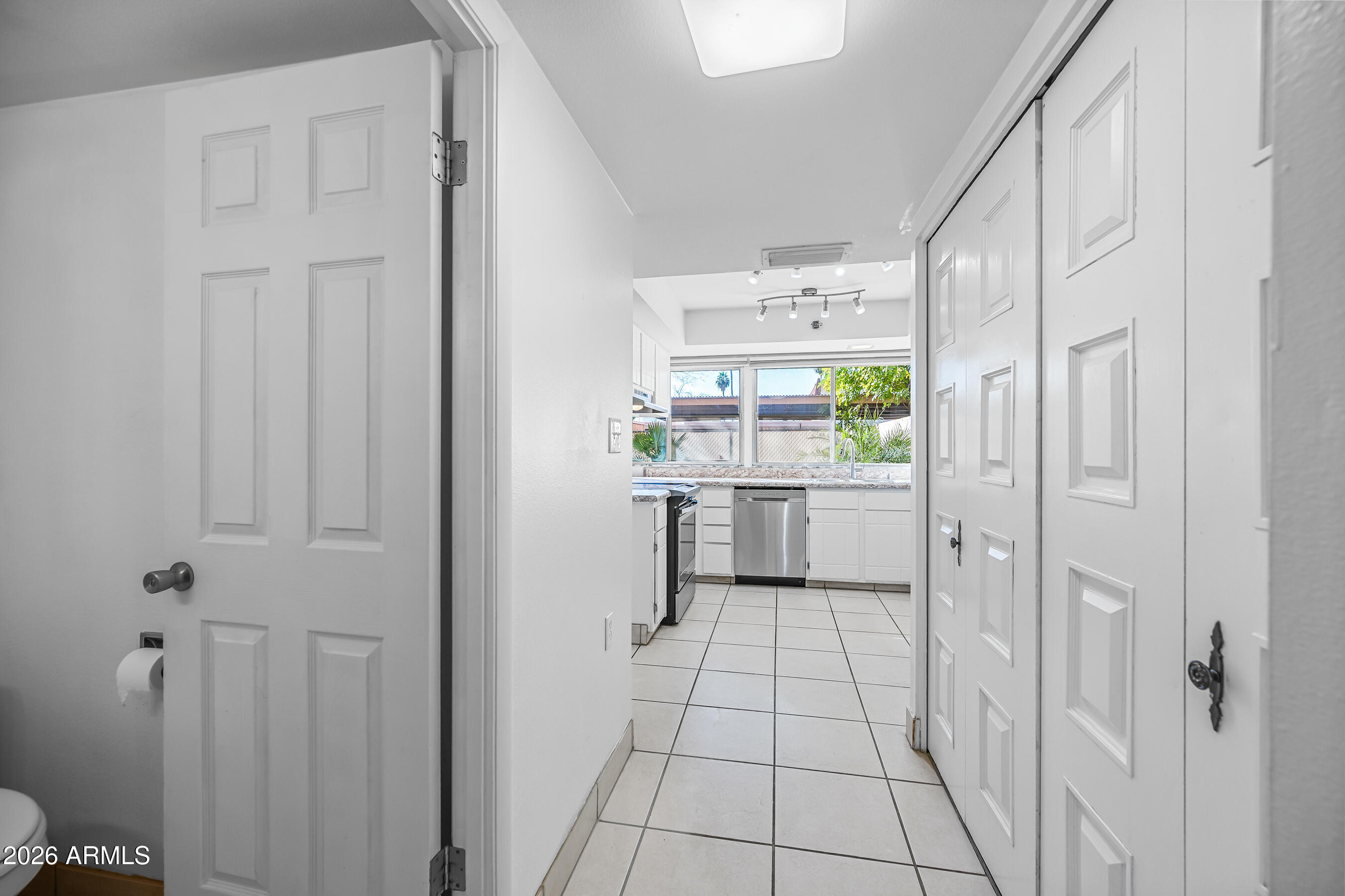 4815 South Birch Street Tempe, AZ 85282 - Photo 11 of 25 a kitchen with stainless steel appliances a refrigerator sink and white cabinets