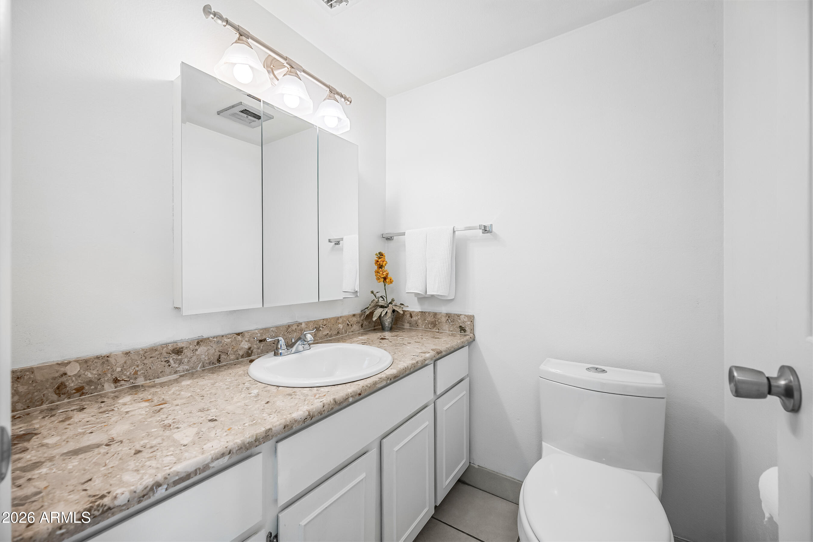 4815 South Birch Street Tempe, AZ 85282 - Photo 12 of 25 a bathroom with a granite countertop sink a toilet and a mirror