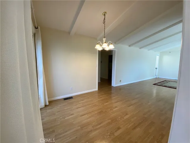 a view of an empty room with a chandelier fan