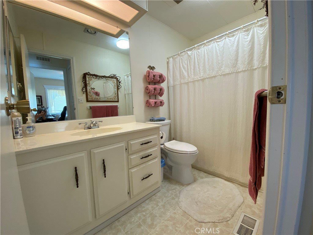 9607 Rosedale Drive Calimesa, CA 92320 - Photo 15 of 27 a bathroom with a sink mirror vanity and toilet