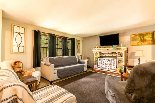 a living room with furniture a flat screen tv and a large window