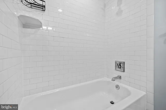 a bathroom with a white bath tub and a shower