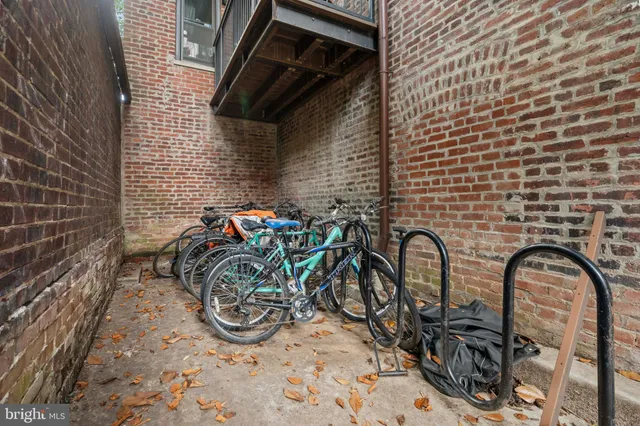a couple of bicycles parked next to a brick wall
