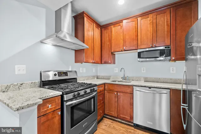 a kitchen with stainless steel appliances granite countertop a stove a sink and a microwave