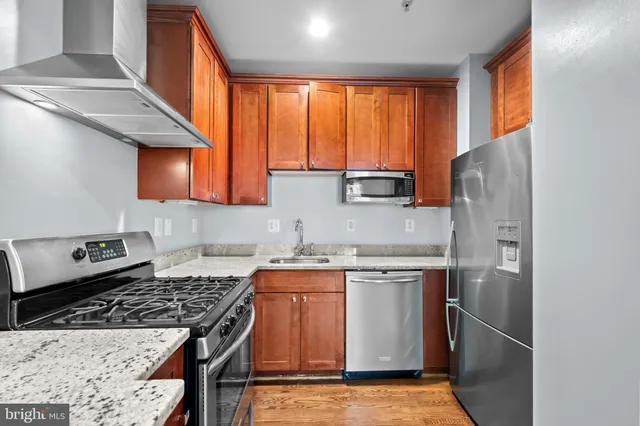 a kitchen with stainless steel appliances granite countertop a stove a refrigerator and a sink
