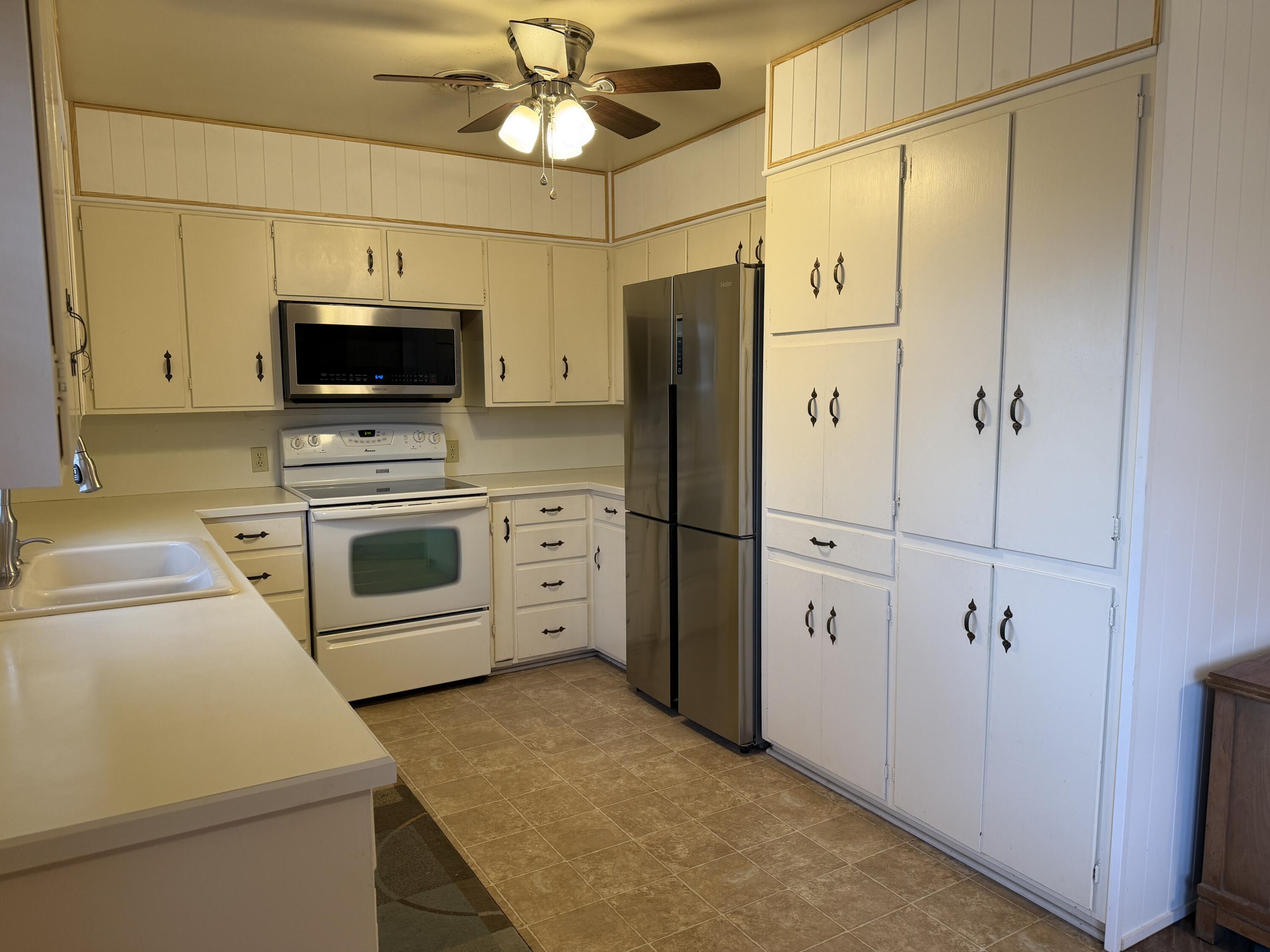 303 North 21st Place Lamesa, TX 79331 - Photo 13 of 35 a kitchen with stainless steel appliances a refrigerator stove and microwave