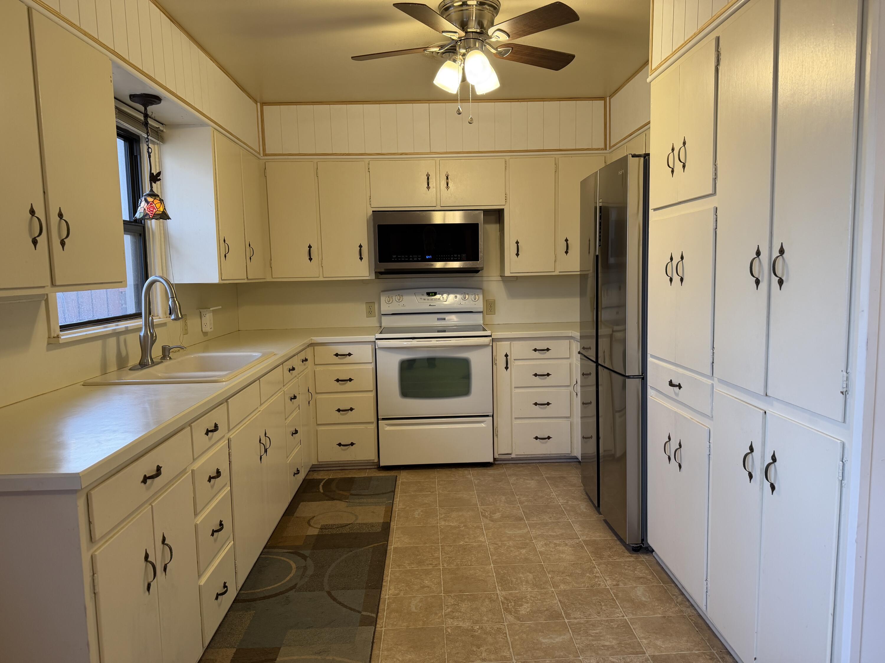 303 North 21st Place Lamesa, TX 79331 - Photo 14 of 35 a kitchen with stainless steel appliances a stove a sink and a refrigerator