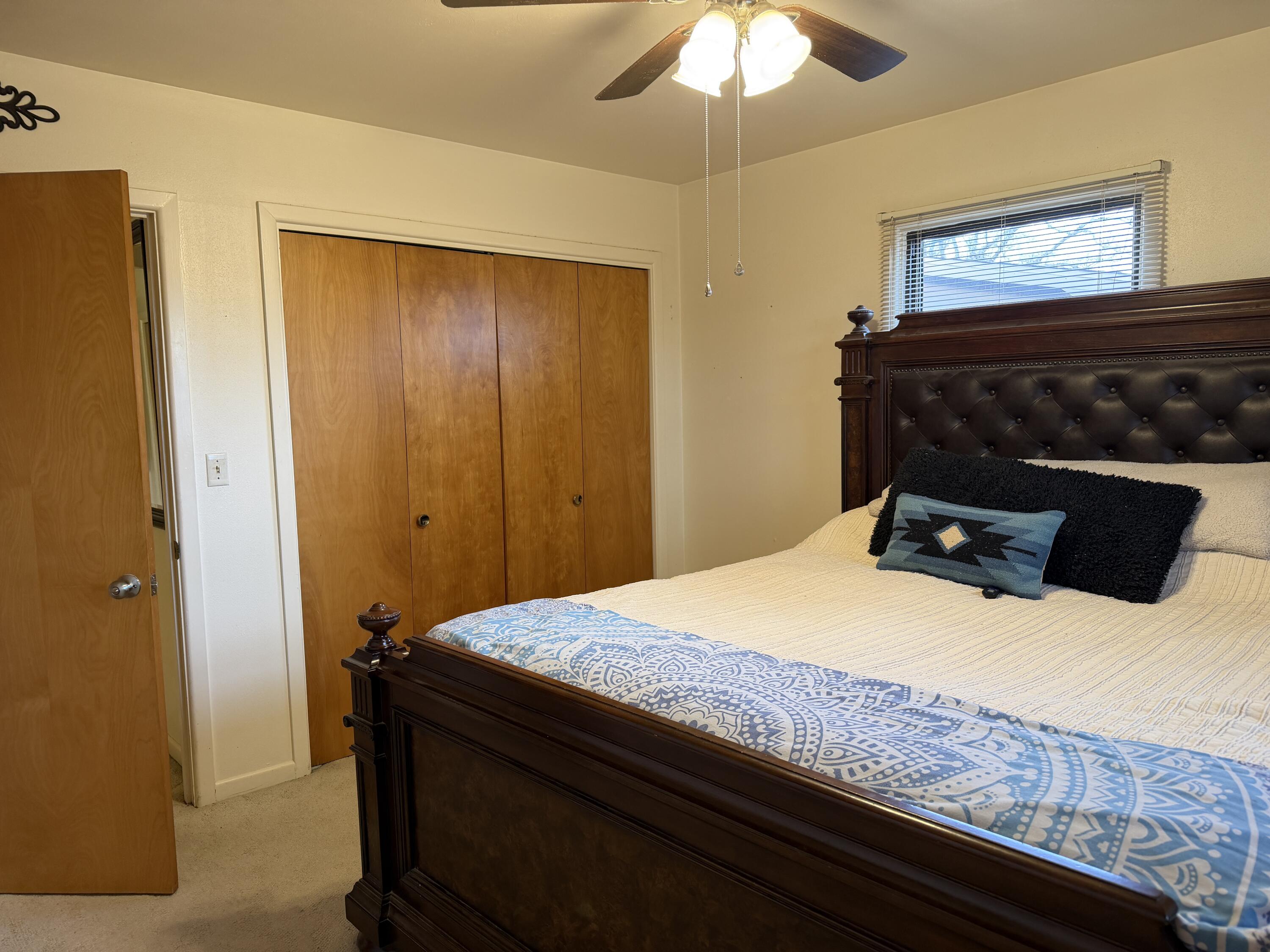 303 North 21st Place Lamesa, TX 79331 - Photo 21 of 35 a bedroom with a bed and a chandelier