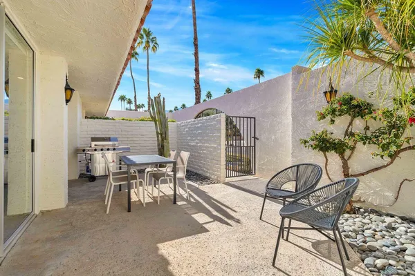 a dinning table and chairs in patio of a house