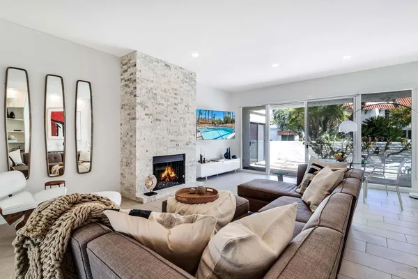 a living room with furniture fireplace and a large window