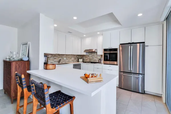 a kitchen with stainless steel appliances granite countertop a refrigerator and a stove