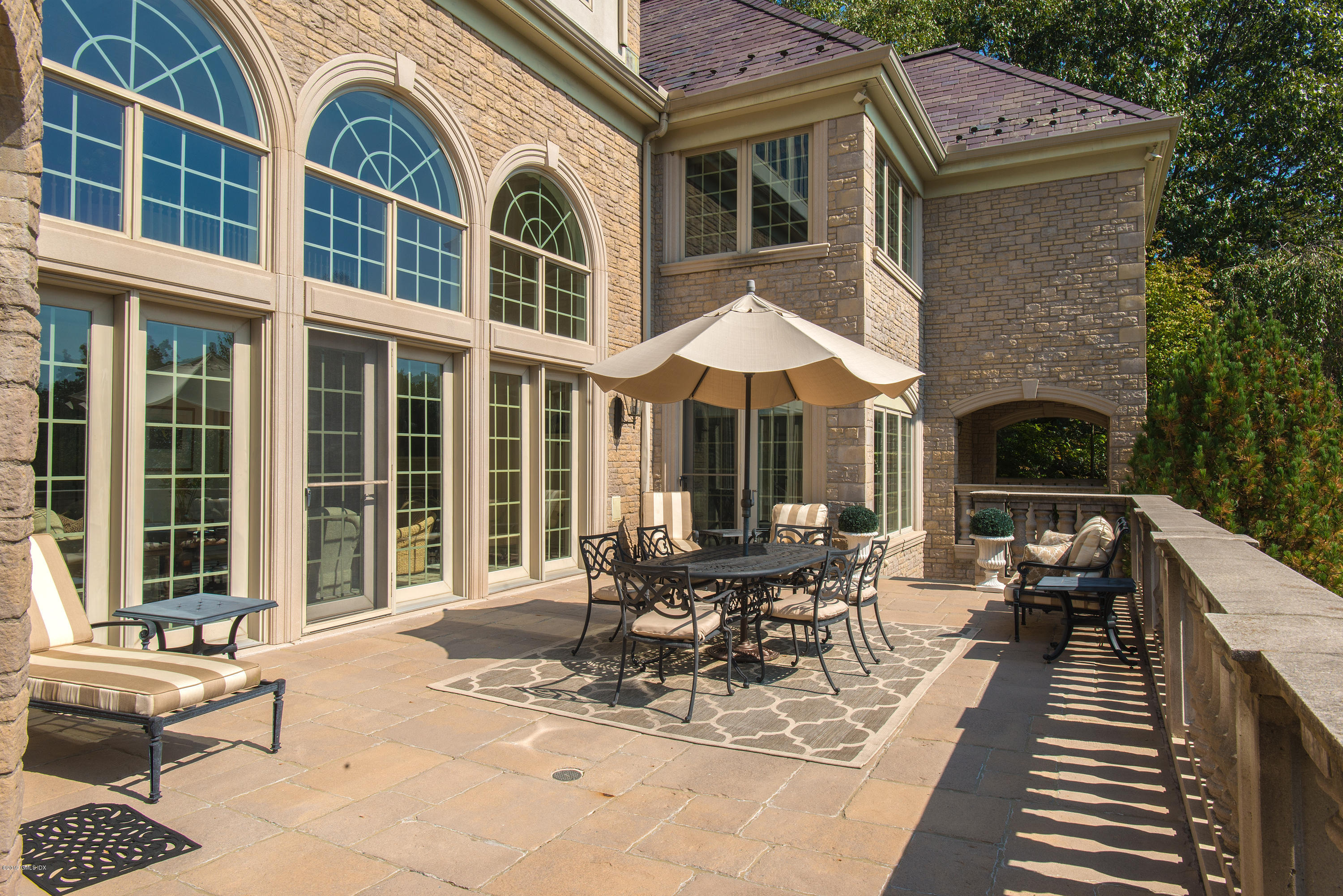56 North Stanwich Road Greenwich, CT 06831 - Photo 23 of 30 a view of a patio with couches table and chairs with wooden floor and fence
