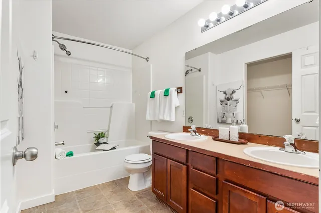 a bathroom with a granite countertop sink mirror toilet and bathtub