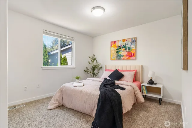 a bed room with a bed and a painting on the wall