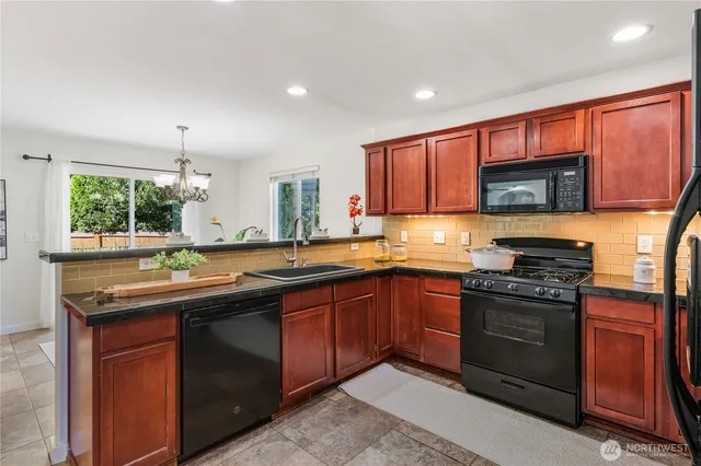 a kitchen with stainless steel appliances granite countertop wooden cabinets stove top oven and sink