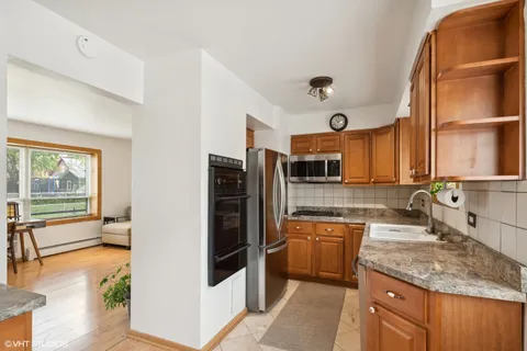 a kitchen with stainless steel appliances granite countertop a stove a sink and a refrigerator