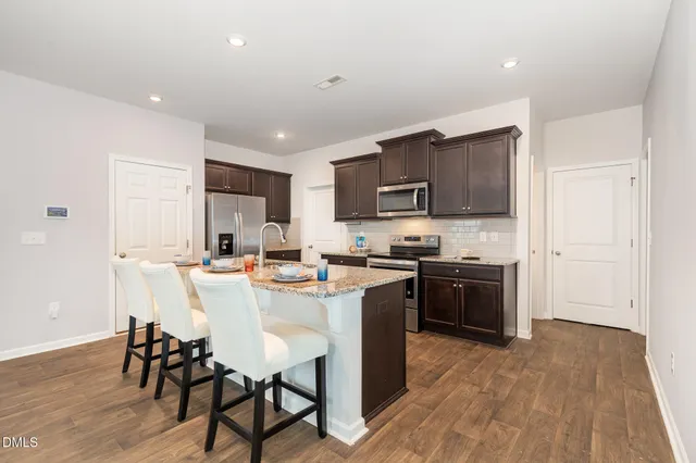 a kitchen with kitchen island wooden cabinets and stainless steel appliances