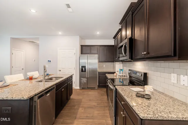 a view of a dining room with furniture a rug and wooden floor