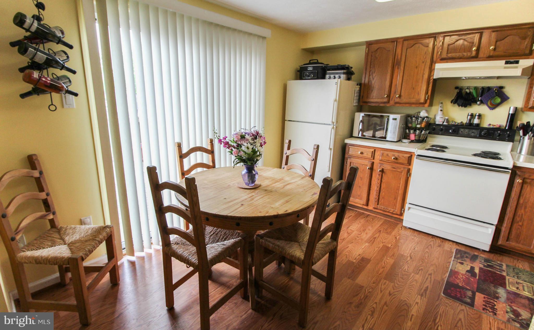 2242 Riding Crop Way Baltimore, MD 21244 - Photo 7 of 20 a kitchen with stainless steel appliances granite countertop a dining table chairs and a refrigerator