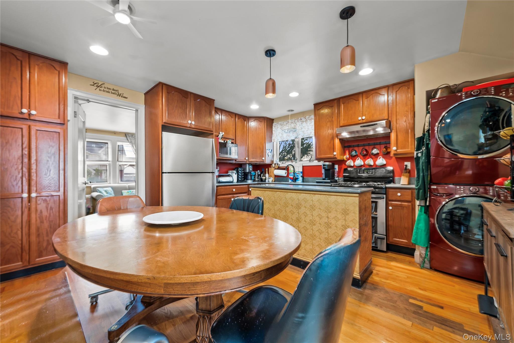 112-45 178th Street Queens, NY 11433 - Photo 8 of 24 a kitchen with stainless steel appliances granite countertop a sink dishwasher a refrigerator a dining table and chairs with wooden floor